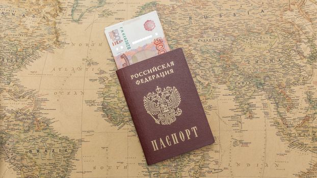 Russian passport with money within on the world map