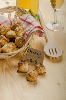 Cheesy bites with seeds, wine in wicker basket, nice gift