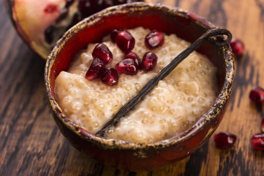 A bowl of tapioca pudding with vanilla and pomegranate