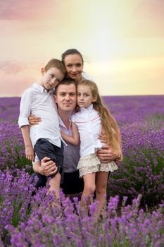Family of four among lavender field at sunset