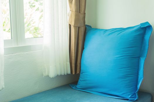 blue pillow near in glass window with soft light in the morning