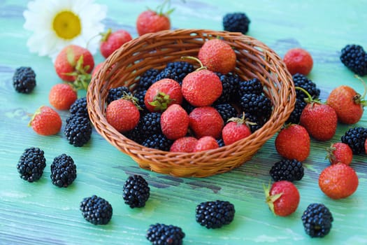 Blackberries and strawberries from the garden on wooden background