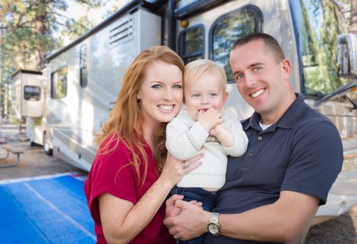 Happy Young Military Family In Front of Their Beautiful RV At The Campground.