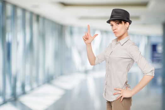 woman in black hat keeps fingers gun in the office