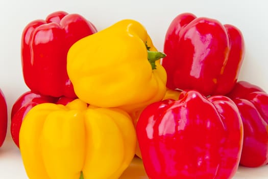 Photo of fresh red and yellow raw pepper on white background