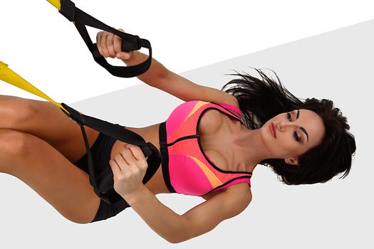 Woman exercising with suspension straps
