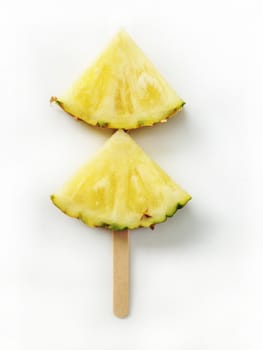 Pineapple slices isolated with popsicle sticks on white backgrou