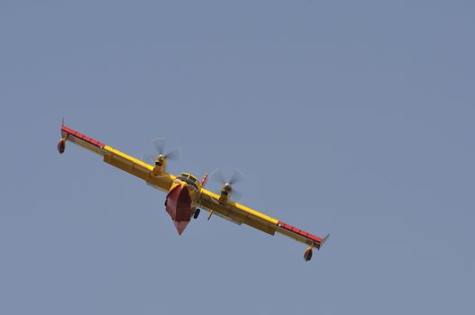 Yellow and red Canadair water bomber, turbo prop firefighting ai