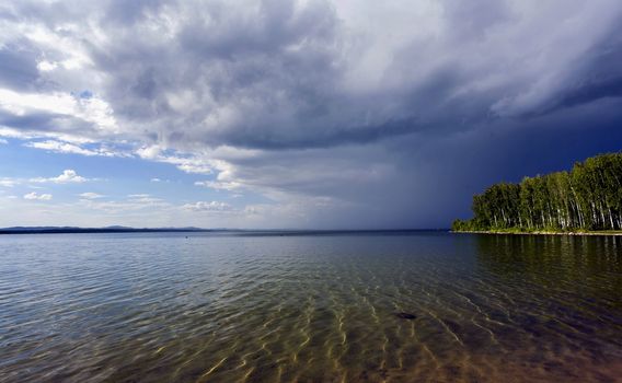 dark storm clouds before rain above the lake