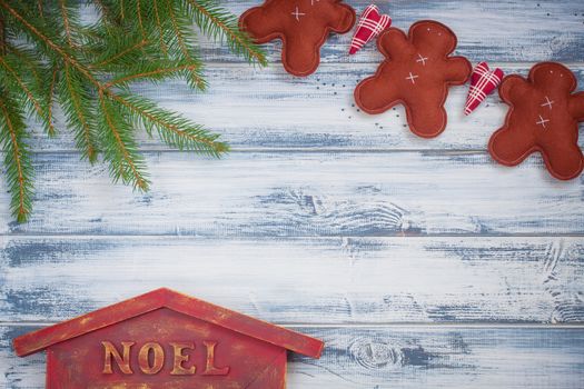 Handmade ginger men, Christmas-tree branches, Noel house on wooden background