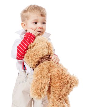 Little blond boy hugging bear toy standing isolated on white