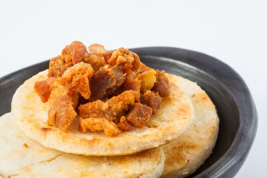 Traditional Colombian arepa topped with pork rind
