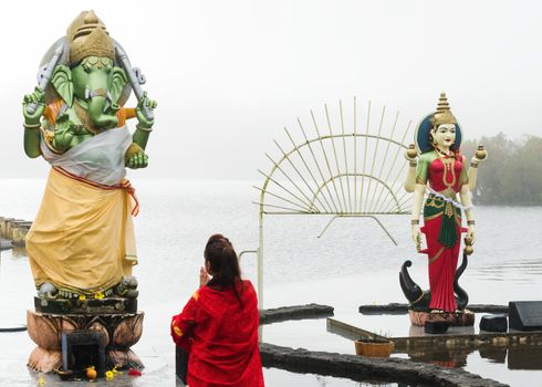 Woman pray in front of hindu Deity