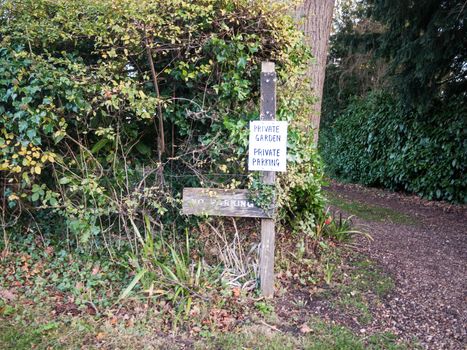 private garden no parking sign on wooden post outside country