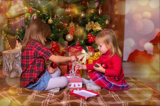 Girls of the sister sort gifts under a Christmas tree