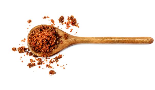 Homemade Salt with Dried and Crushed Sweet Red Paprika in Wooden Spoon isolated on White background