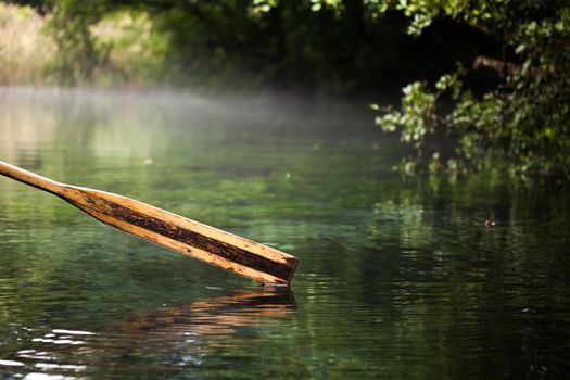 wooden paddle over misty water