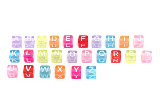 Colorful plastic beads alphabet isolated on a white background.