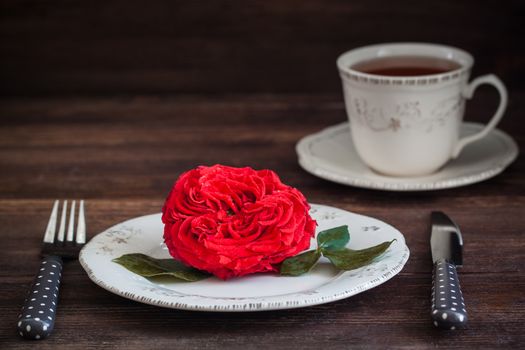 Romantic dinner setting with fresh red garden rose. Valentine or Wedding postcard concept