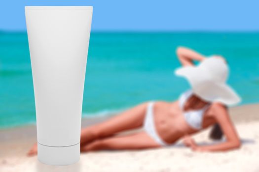 Tube of sun lotion with slim tanned woman on a beach behind. Sum