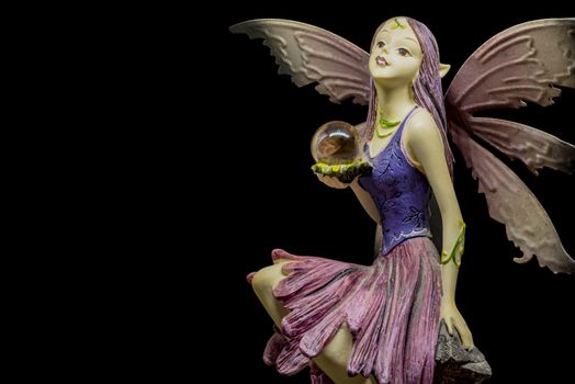 female elf figurine holding crystal ball
