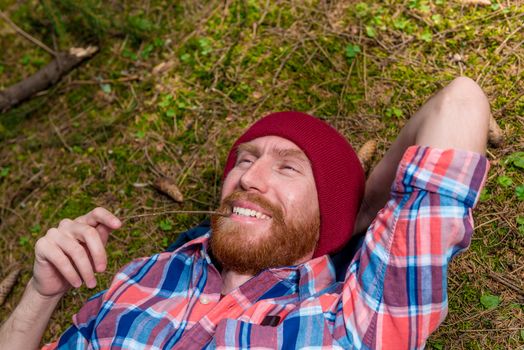 close-up portrait of a happy man with a beard lying on the groun