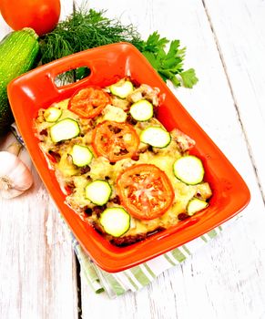 Casserole from minced meat and zucchini in brazier on board