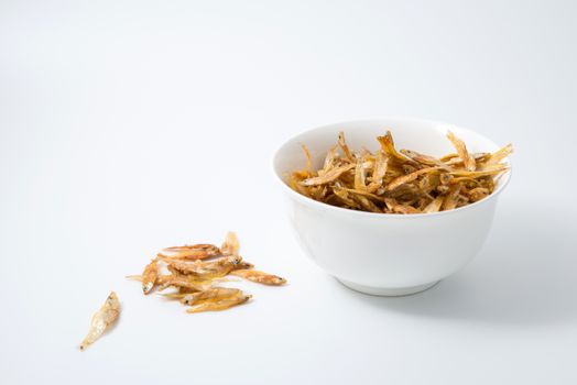 fried small fish in a cup on white background