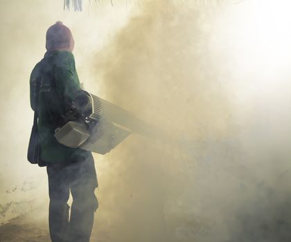 Man work fogging to eliminate mosquito for preventing spread den