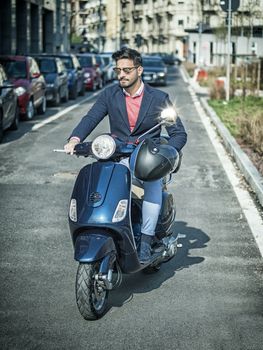 Trendy man on scooter in city setting in the day