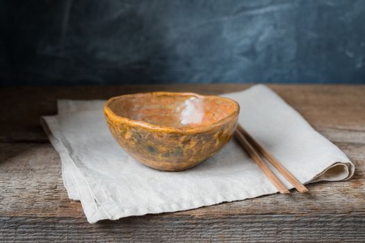 Handmade ceramic bowl on a wooden background, wabi sabi style