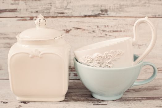 Simple rustic white and blue crockery, empty dishes. Two large bowls each other and porcelain jar with lid. Wooden background, shabby chic, vintage tinting