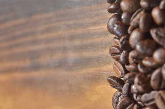 Coffee beans lie on the right on a light wooden background.