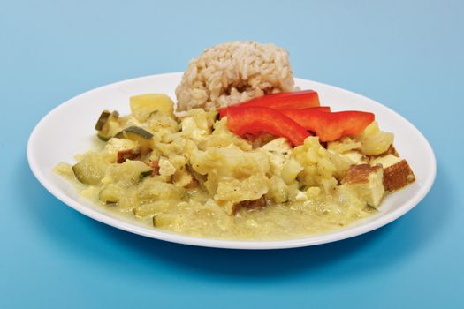 Cauliflower mixture with curry and rice on a blue