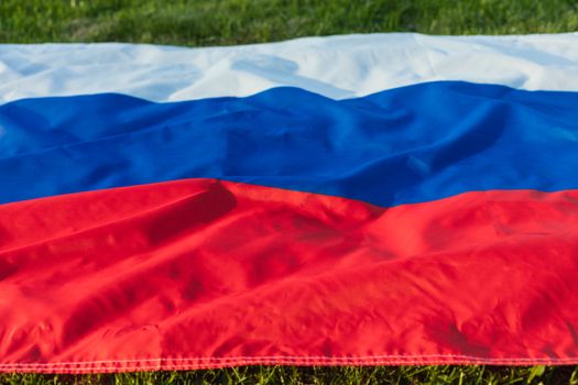 Russian flag lying on the green grass