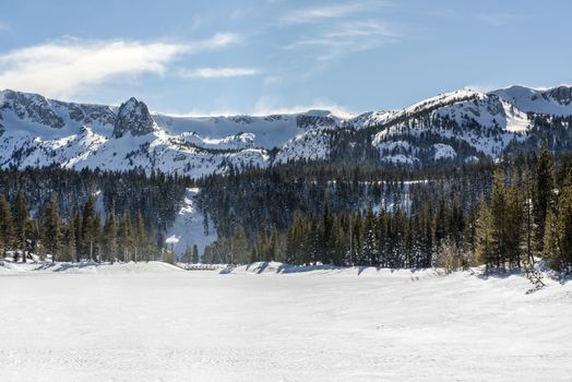 View of Twin Lakes frozen in winter with Mammoth Rock in backgro