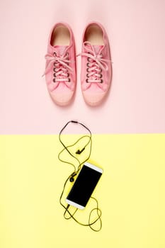 Pink canvas sneakers and mobile phone