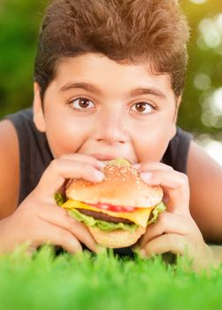 Hungry boy eating burger