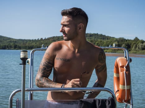 Handsome tattooed young man in boat