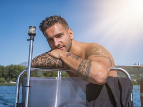 Handsome tattooed young man in boat