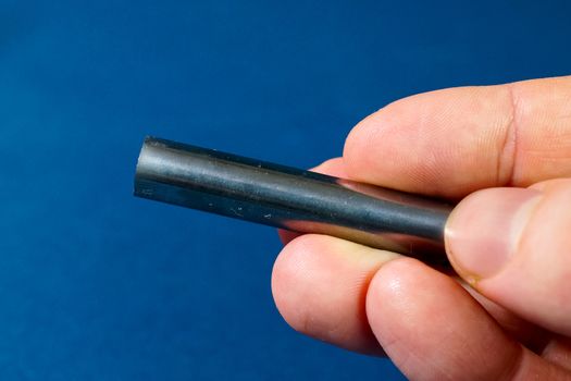 Tungsten rod in the hand. A piece of tungsten for experiments
