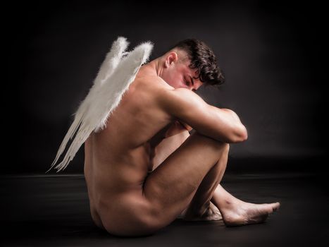 Fallen male angel with white wings