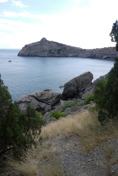 The wide bay is surrounded by high Crimean rocks covered with gr