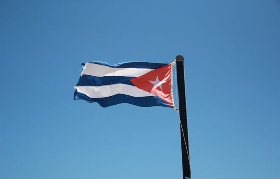 A large national flag of Cuba, fluttering in the breeze