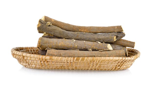 Liquorice roots in basket on white background