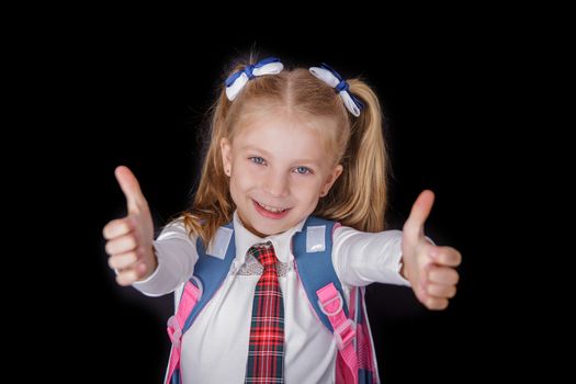 Schoolgirl showing thumbs up sign using both hands at the black background