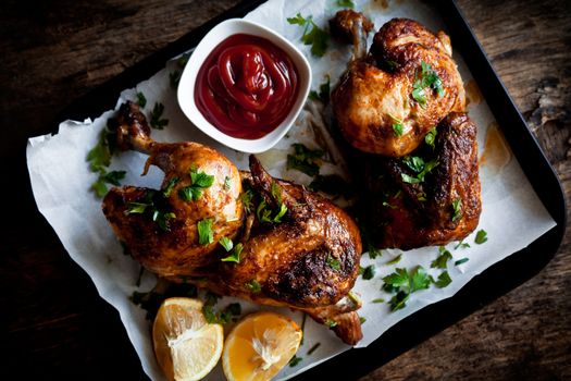 Halves Of A Roasted Chicken With Herbs And Ketchup