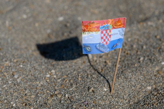 Touristic flag of Croatia picked in Sand on Beach