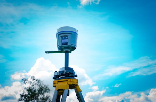 GPS surveying instrument on blue sky background