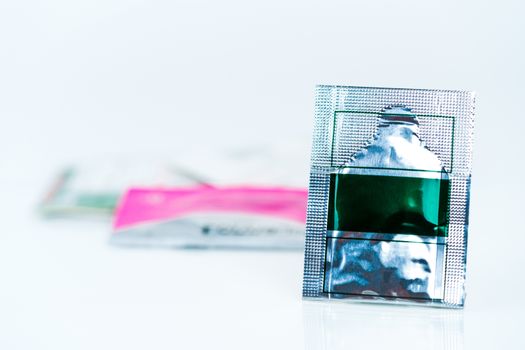 Mild steroid oral paste in aluminium foil sachet on blur background of sachets. Anti-inflammatory for oral mucous membrane, relief oral tenderness, pain, and ulceration. Aphthous ulcer or mouth ulcers